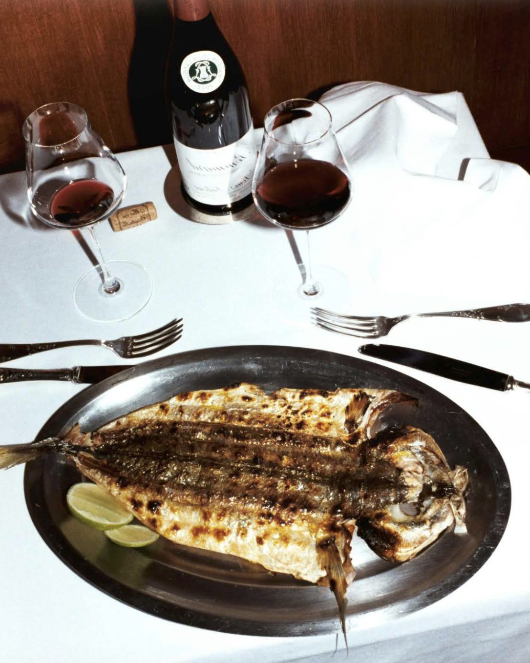 Grilled fish and red Burgundy on a white tablecloth